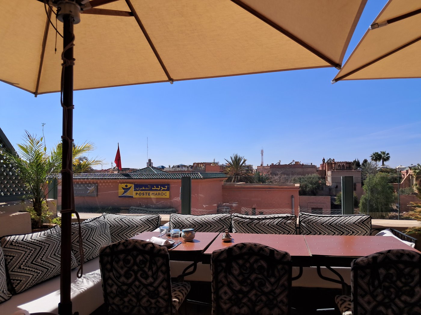 The rooftop of the Moroccan Culinary Arts Museum, Marrakesh — mint tea, a parasol, and a view over the medina