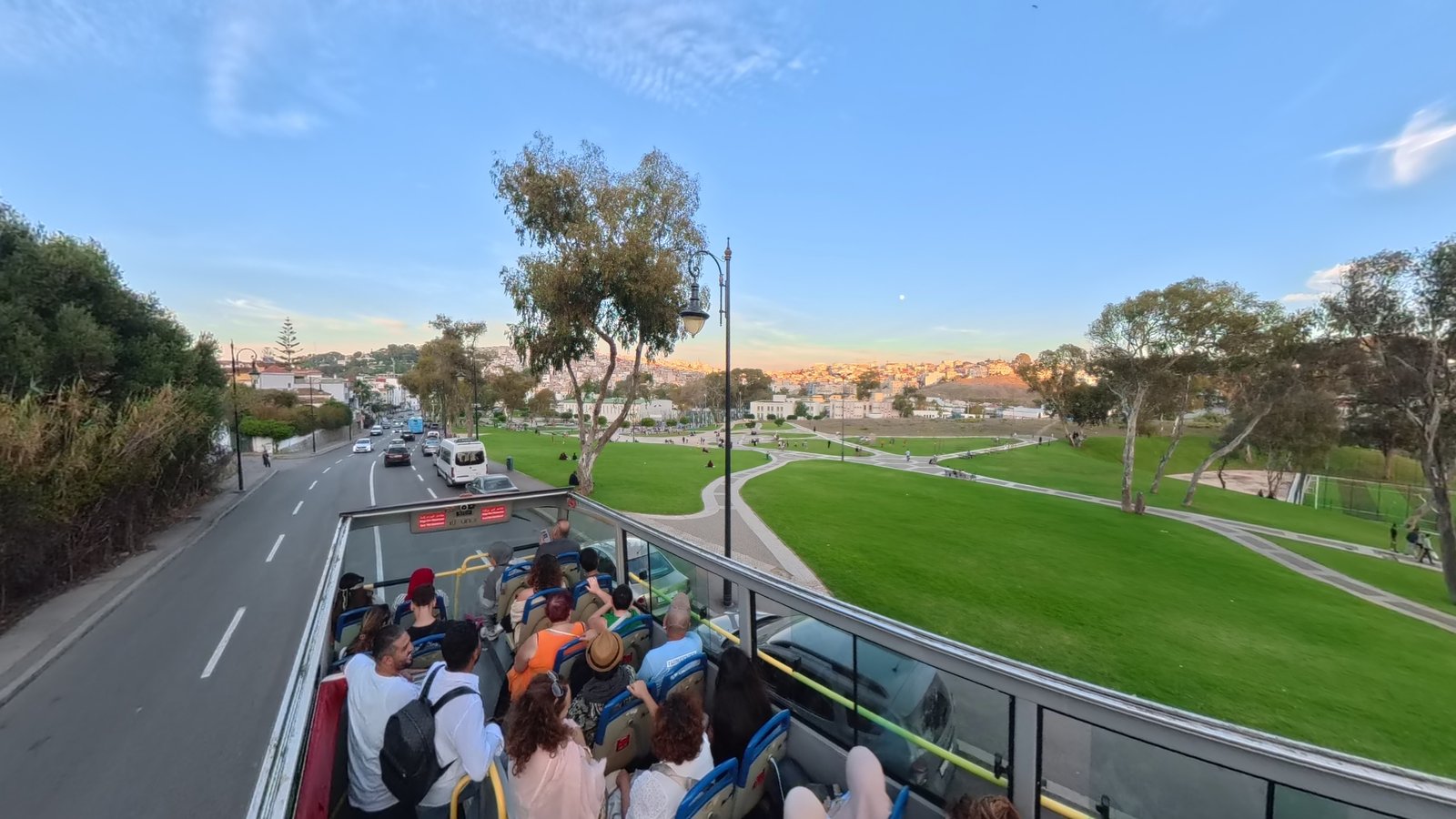 Tangier from the open-top tour bus at sunset — the gardens and the city on the hill